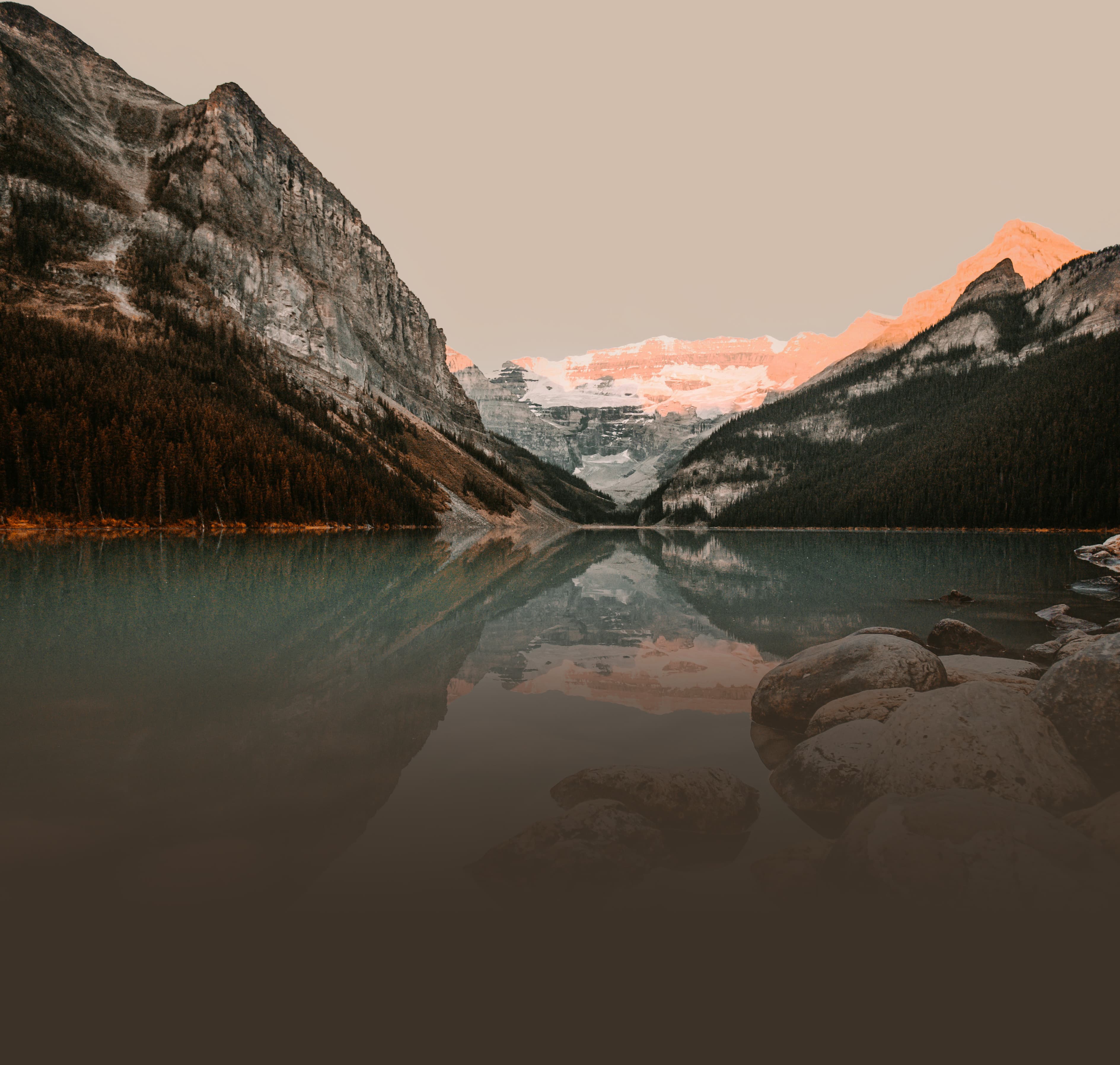 Luce del mattino sulle montagne, riflesse nell’acqua di un lago
